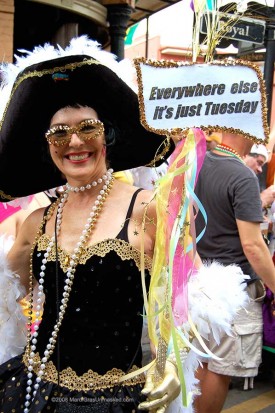 Female Mardi Gras masker with sign reading "Everywhere Else It's Just Tuesday"