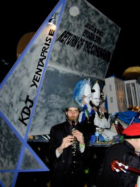 Ben Schenck, leader of the Panorama Jazz Band, playing his clarinet alongside the Krewe du Jieux’s Yentaprise float in the 2001 Krewe du Vieux parade