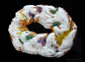 New Orleans-style king cake with purple, green and gold sugar and sprinkles, and fondant icing