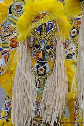 Yellow suit with African-style mask covering his face