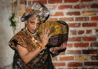 Voodoo Priestess Resa "Cinnamon Black" Bazile holding a basket